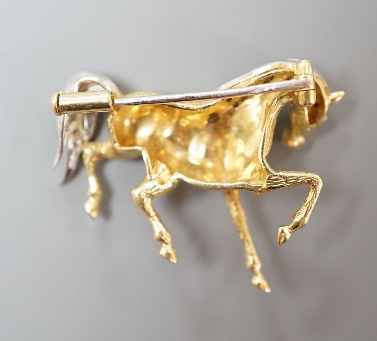 A modern 18ct gold and diamond chip set horse brooch, 29mm, gross weight 7.4 grams.